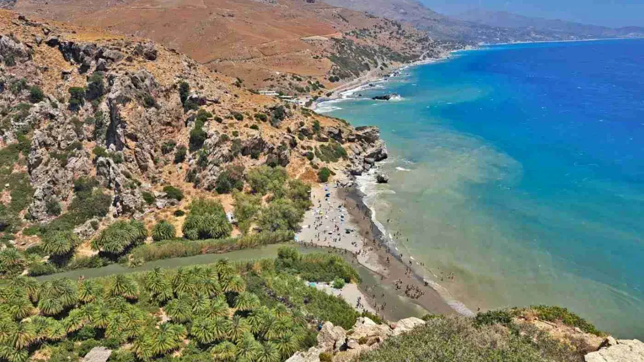Spiaggia con palme e fiume in Grecia, ideale per una vacanza in famiglia in un grecia family hotel.