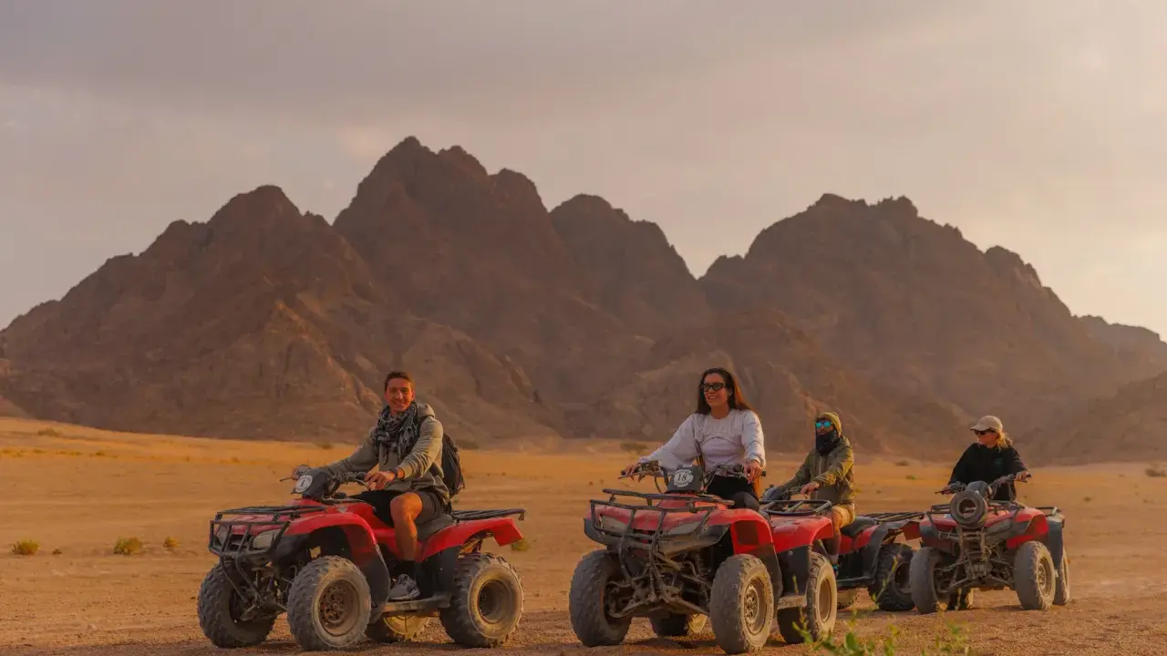 Un gruppo di persone si diverte in quad nel deserto egiziano, un'avventura indimenticabile a Sharm el Sheikh con bambini.