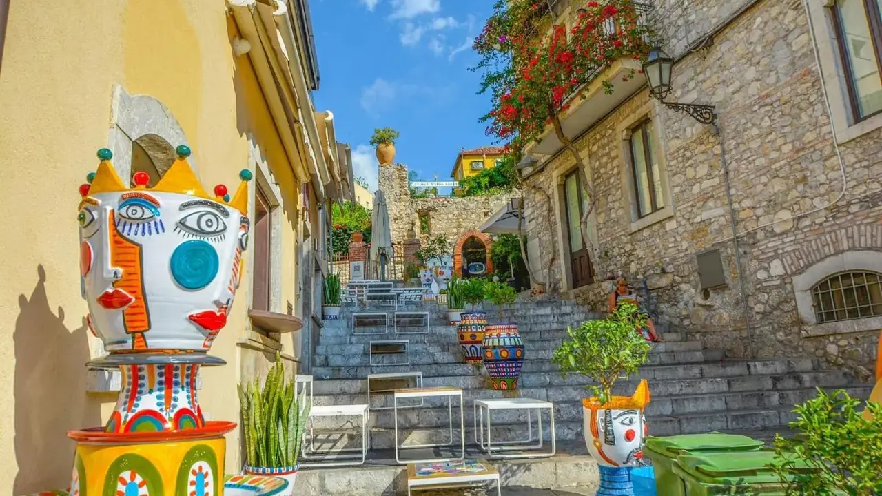 Colorate ceramiche artistiche adornano una scalinata a Taormina, un luogo incantevole per famiglie con bambini.