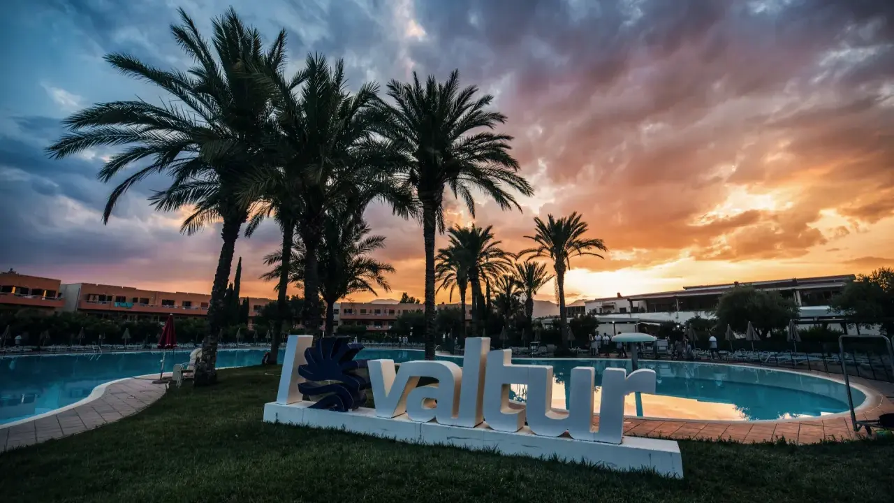 Tramonto infuocato sul Valtur Calabria Otium Resort. Palme e piscina creano un'atmosfera da sogno.