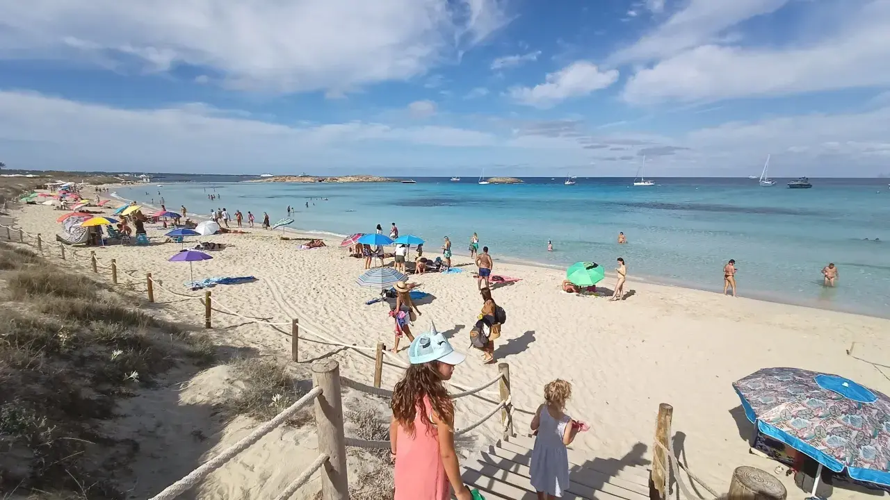 Giornata di sole a Formentera con bambini, tra sabbia bianca, mare cristallino e tante famiglie che si godono la vacanza.