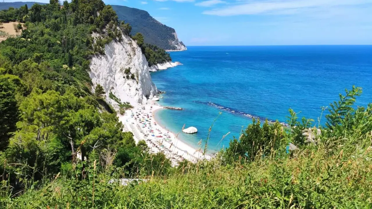 Le splendide spiagge del Conero, con la loro sabbia bianca e il mare cristallino, incorniciate da scogliere a picco e vegetazione lussureggiante.