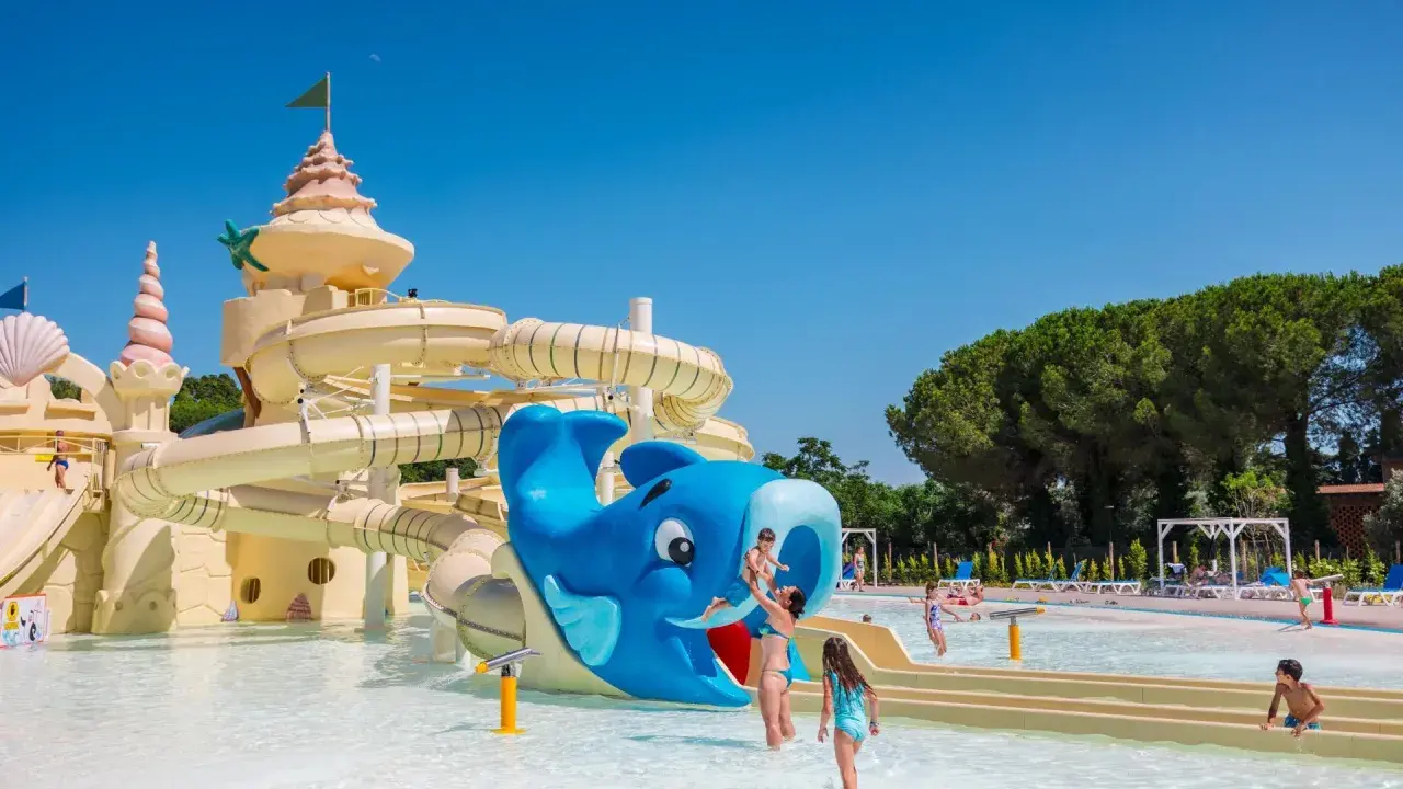 Un parco acquatico con scivoli a forma di castello e balena blu, ideale per campeggi in Toscana sul mare per bambini.