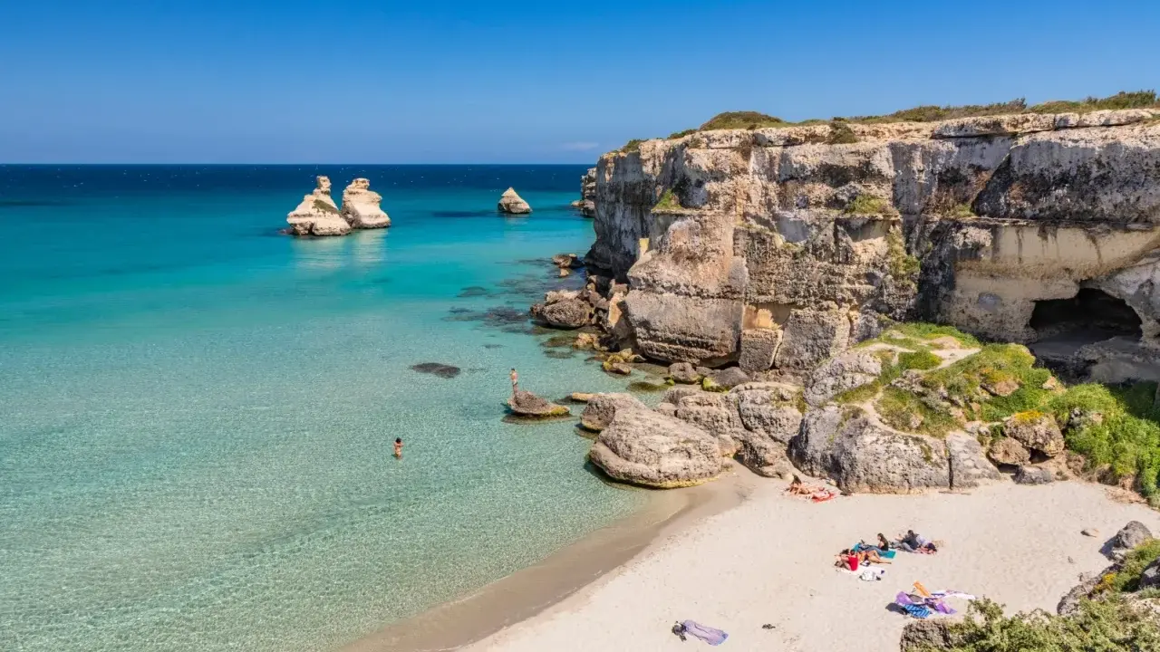 Spiaggia con scogli e mare cristallino, un angolo di paradiso in Puglia dove andare al mare.