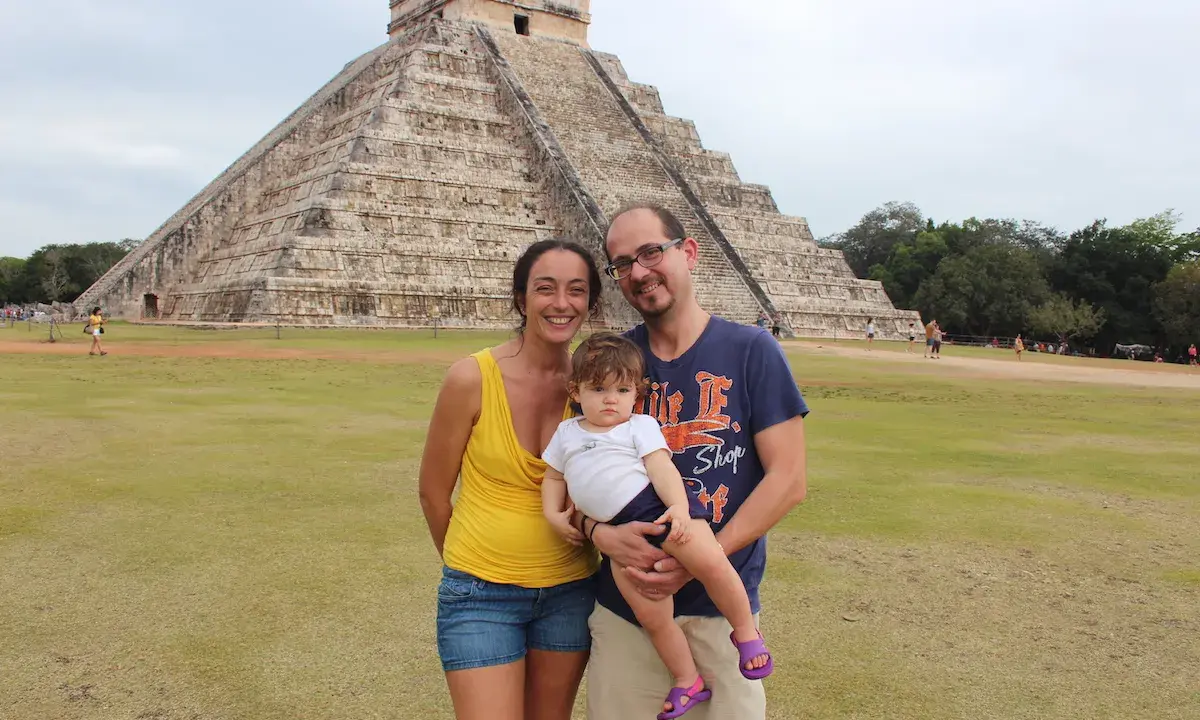 Famiglia felice in vacanza in Messico con bambini, davanti alla piramide di Chichen Itza.