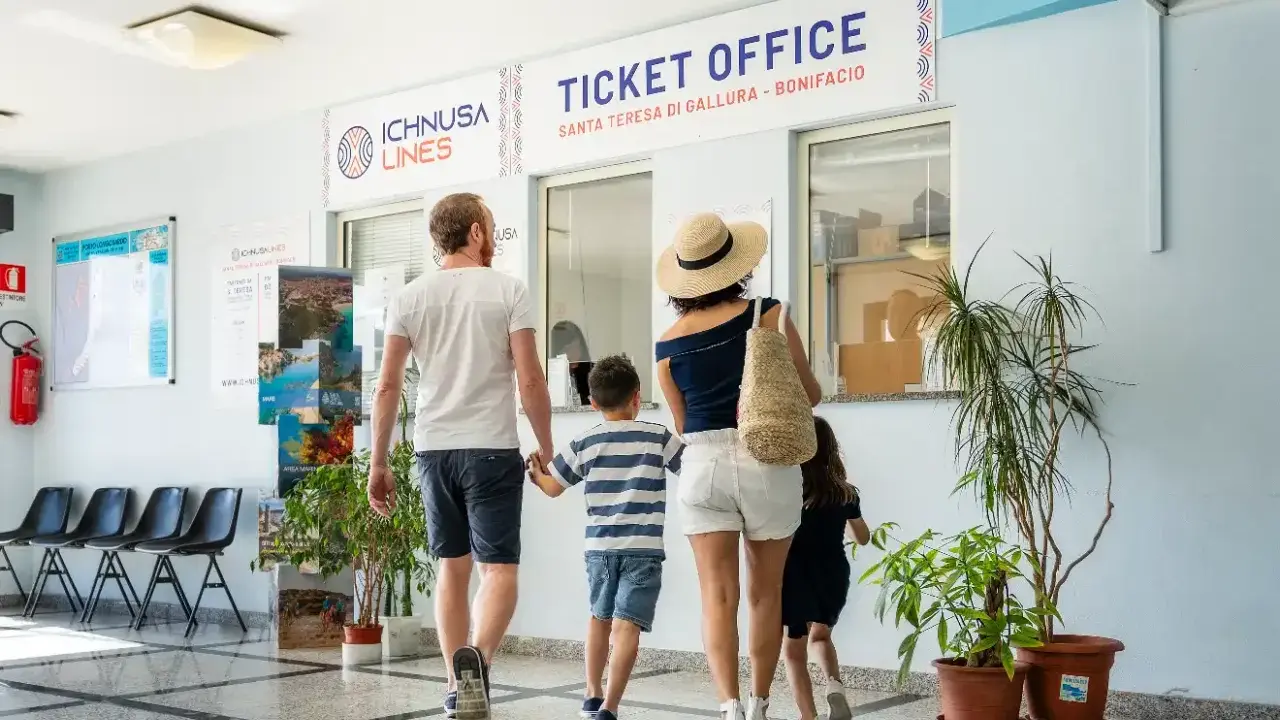 Famiglia in coda all'ufficio biglietti per la Corsica con bambini, pronti per l'avventura.