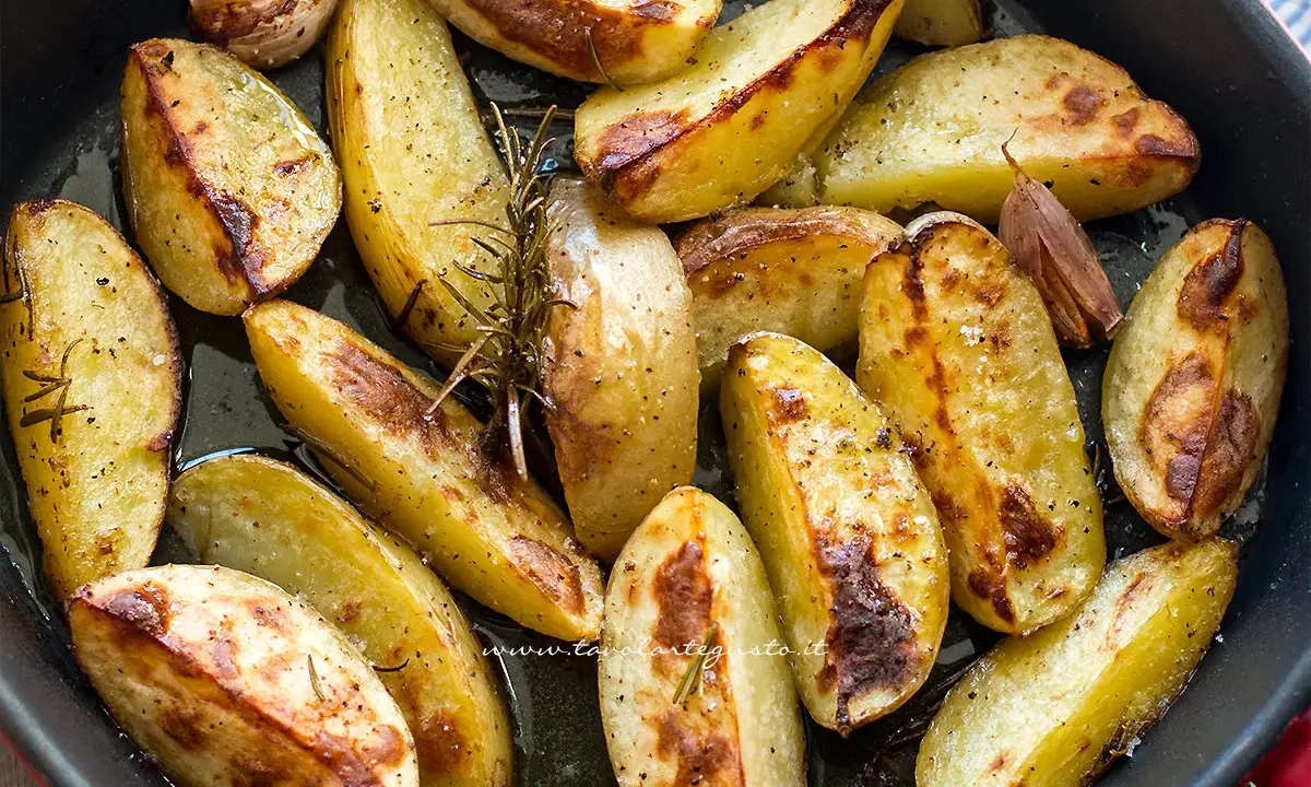 Patate al forno dorate e croccanti, condite con rosmarino e aglio, pronte per essere gustate.