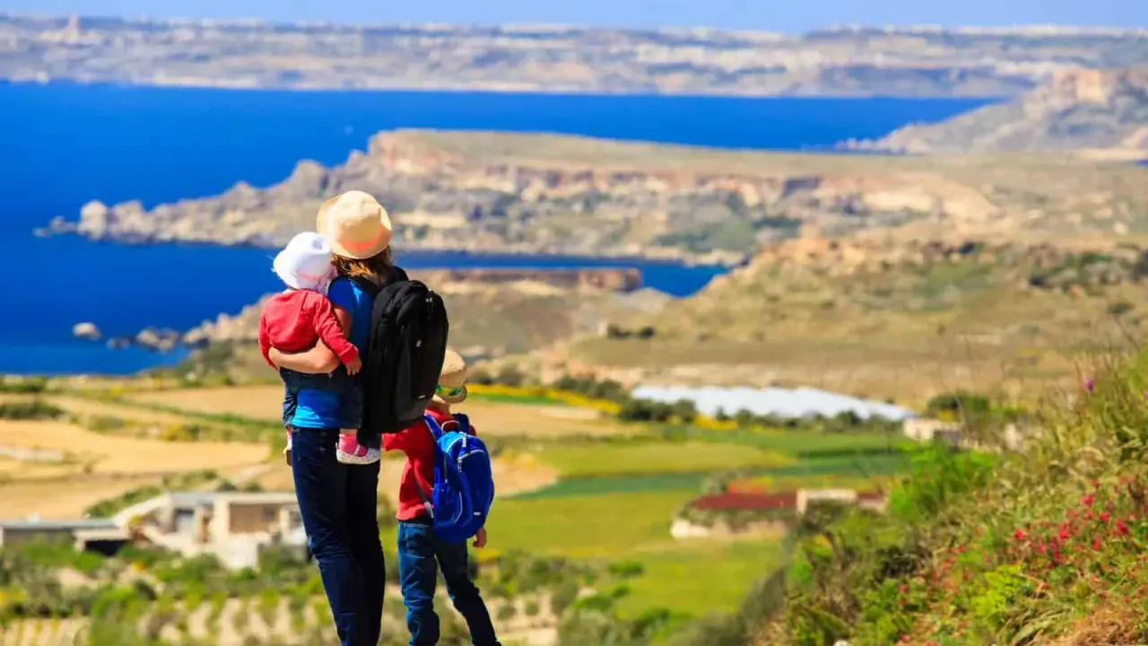 Madre con bambini ammira il panorama di Malta. Un'avventura indimenticabile per tutta la famiglia.