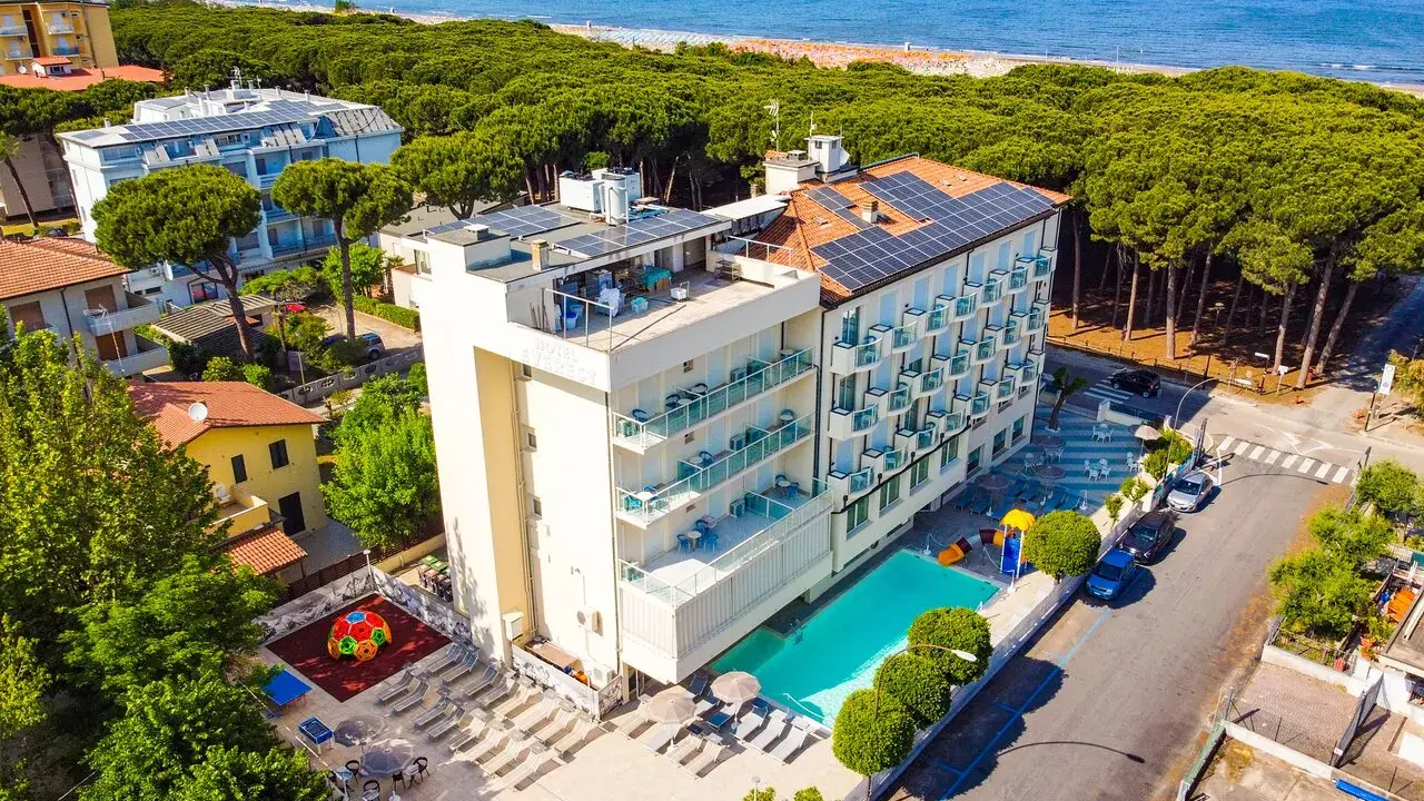 Hotel Primula Azzurra, con piscina, area giochi e vista mare, immerso nel verde di una pineta.