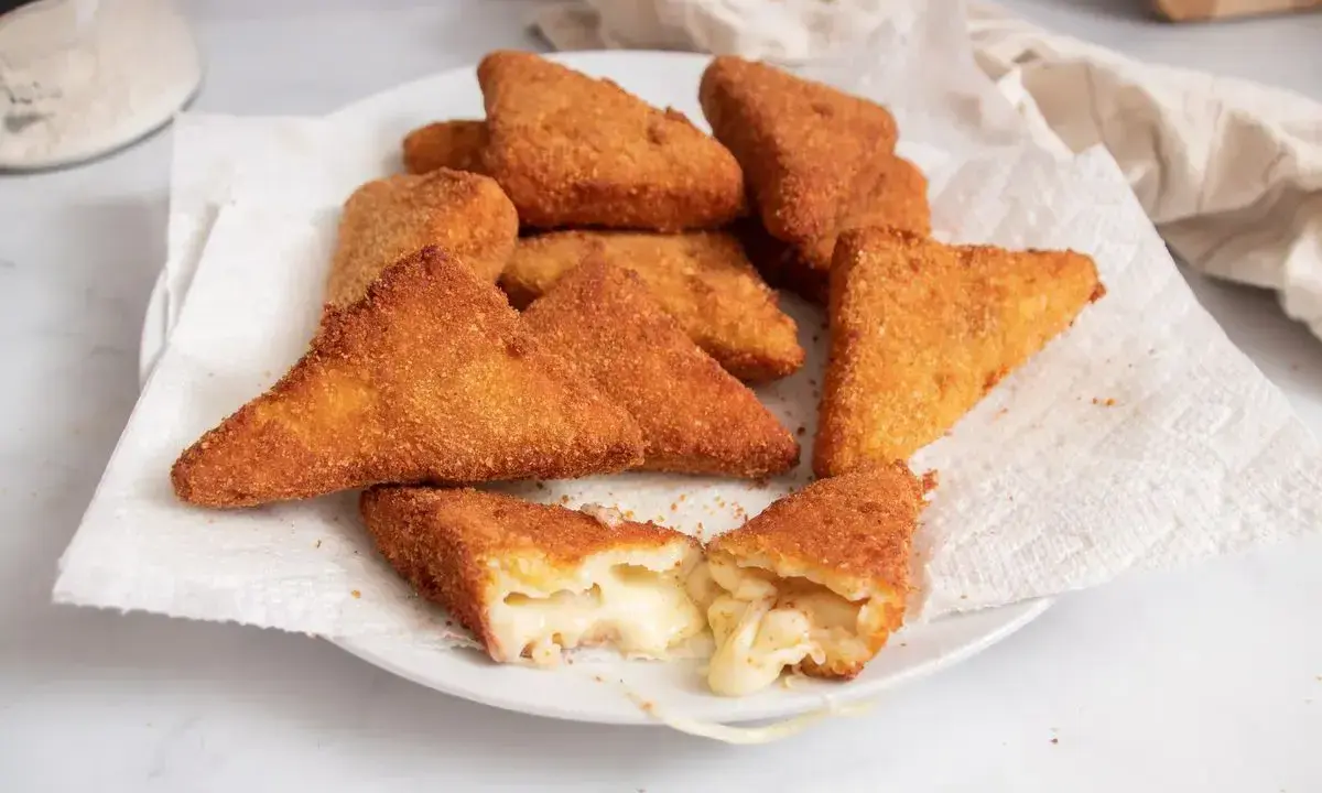 Mozzarella in carrozza dorate e croccanti, una fetta mostra il formaggio filante all'interno.