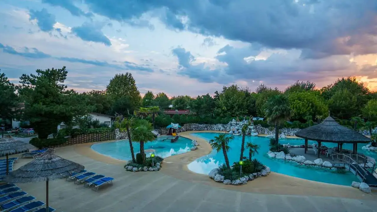 Villaggio vacanze con piscine azzurre, palme e lettini prendisole. Un angolo di paradiso, un vero tahiti camping village.