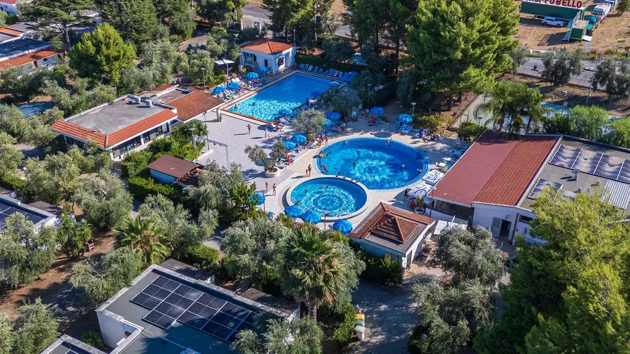 Viste panoramiche del Sea Garden Club Vieste: piscine, ombrelloni blu e vegetazione rigogliosa.