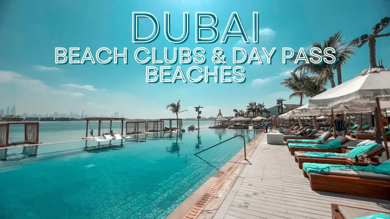 Piscina a sfioro e lettini prendisole in un lussuoso beach club di Dubai, con palme e vista sullo skyline.