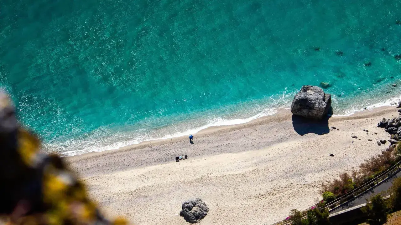 Spiaggia dorata e mare turchese in Liguria. Un pescatore solitario ammira la bellezza del **liguria mare**.