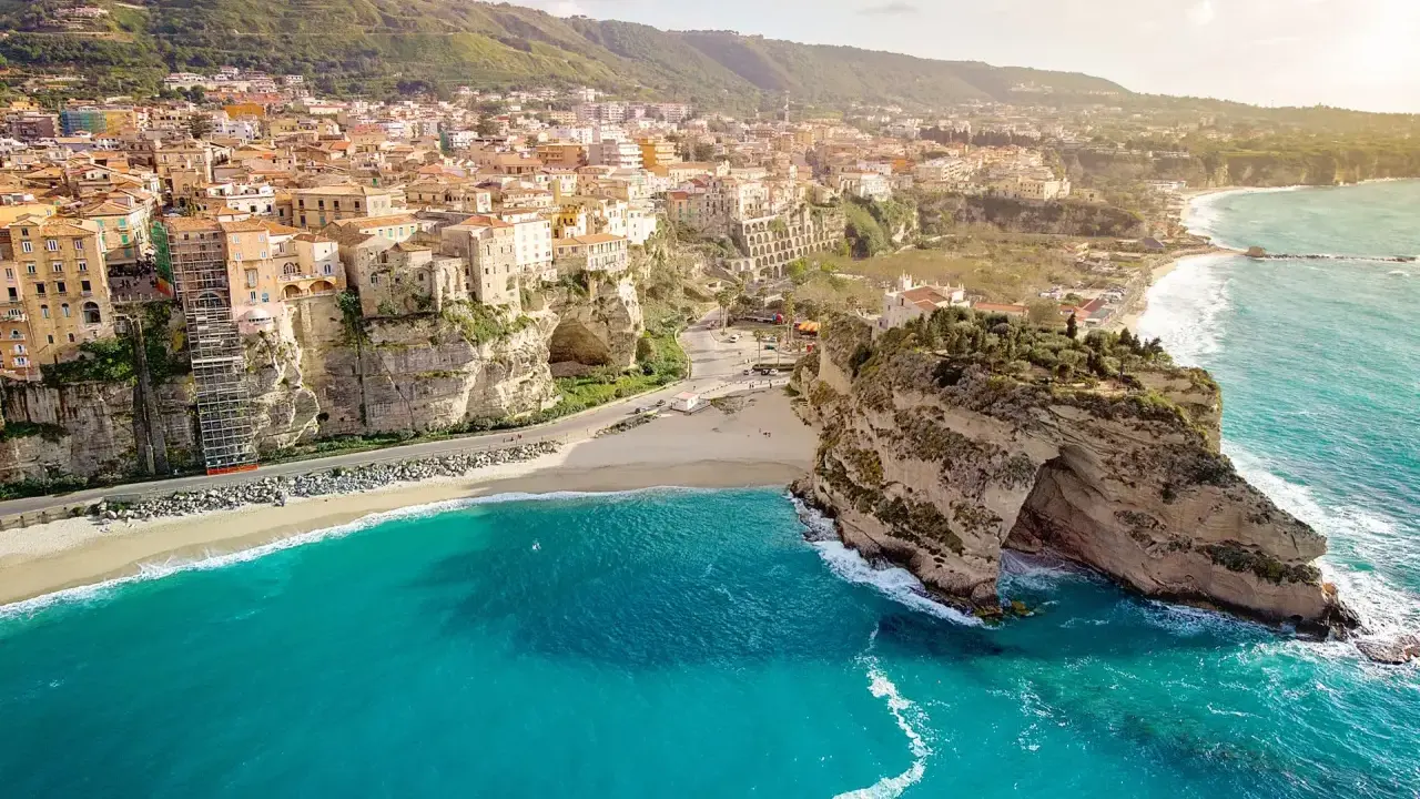 Panoramica mozzafiato delle calabria spiagge con case colorate aggrappate alle scogliere e un mare cristallino.