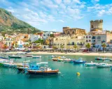 Un incantevole scorcio di Ischia con bambini che sognano gite in barca. Case colorate, mare azzurro e un castello medievale.