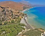 Spiaggia con palme e fiume in Grecia, ideale per una vacanza in famiglia in un grecia family hotel.