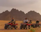 Un gruppo di persone si diverte in quad nel deserto egiziano, un'avventura indimenticabile a Sharm el Sheikh con bambini.