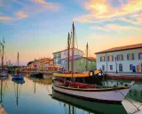 Barche a vela ormeggiate nel porto canale di Cesenatico al tramonto. Un luogo incantevole per scoprire cosa fare a Cesenatico.