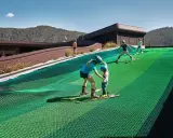 Bambini imparano a sciare su una pista verde al Falkensteiner Family Resort Lido, con montagne sullo sfondo.