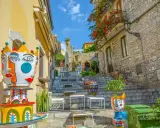 Colorate ceramiche artistiche adornano una scalinata a Taormina, un luogo incantevole per famiglie con bambini.