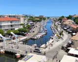 Passeggiata sul canale di Cervia, con barche ormeggiate e negozi. Un'ottima idea per scoprire cosa fare a Cervia in una giornata di sole.