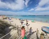 Giornata di sole a Formentera con bambini, tra sabbia bianca, mare cristallino e tante famiglie che si godono la vacanza.