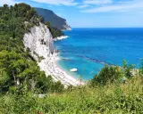 Le splendide spiagge del Conero, con la loro sabbia bianca e il mare cristallino, incorniciate da scogliere a picco e vegetazione lussureggiante.