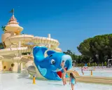 Un parco acquatico con scivoli a forma di castello e balena blu, ideale per campeggi in Toscana sul mare per bambini.