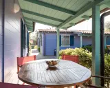 Tavolo con frutta su un portico colorato, con casette in stile villaggi Conero sul mare per bambini sullo sfondo.