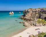 Spiaggia con scogli e mare cristallino, un angolo di paradiso in Puglia dove andare al mare.