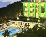 Hotel Biondi Cesenatico: piscina illuminata e facciata verde brillante. Le recensioni lodano l'atmosfera serale.