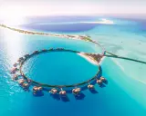 Resort circolare su palafitte nel Mar Rosso Arabia Saudita, con isole sabbiose e acque turchesi.