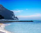 Spiaggia con scogliere e mare azzurro, ideale per scoprire dove andare al mare nelle Marche.