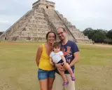 Famiglia felice in vacanza in Messico con bambini, davanti alla piramide di Chichen Itza.
