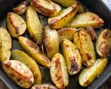 Patate al forno dorate e croccanti, condite con rosmarino e aglio, pronte per essere gustate.