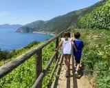 Due bambini esplorano un sentiero panoramico con vista sul mare, un'avventura indimenticabile tra le Cinque Terre con bambini.