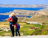 Madre con bambini ammira il panorama di Malta. Un'avventura indimenticabile per tutta la famiglia.