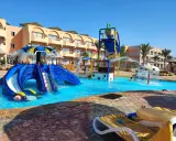Divertimento acquatico a Marsa Alam con bambini: scivoli blu, giochi d'acqua e piscine cristalline in un resort soleggiato.