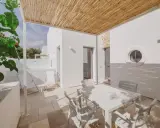 Terrazza con tavolo e sedie bianche, tettoia in bambù, tipica del Nicolaus Club Meditur Village.