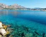 Acque cristalline a San Vito Lo Capo, perfette per una vacanza con bambini. Montagne sullo sfondo, un sogno.