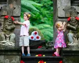 Bambini a Bali esplorano antiche statue decorate con fiori. Un'avventura indimenticabile per i più piccoli.