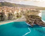 Panoramica mozzafiato delle calabria spiagge con case colorate aggrappate alle scogliere e un mare cristallino.