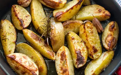 Patate al forno dorate e croccanti, condite con rosmarino e aglio, pronte per essere gustate.