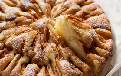 Una deliziosa torta di mele, con fette di mela disposte a raggiera e spolverata di zucchero a velo.