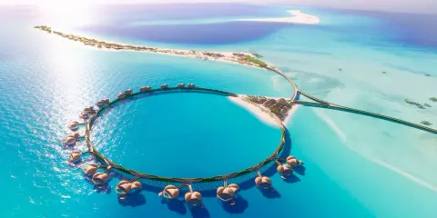 Resort circolare su palafitte nel Mar Rosso Arabia Saudita, con isole sabbiose e acque turchesi.