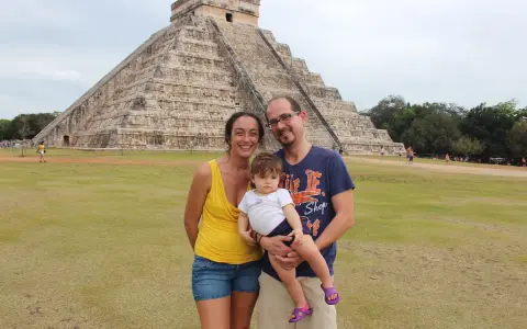 Famiglia felice in vacanza in Messico con bambini, davanti alla piramide di Chichen Itza.