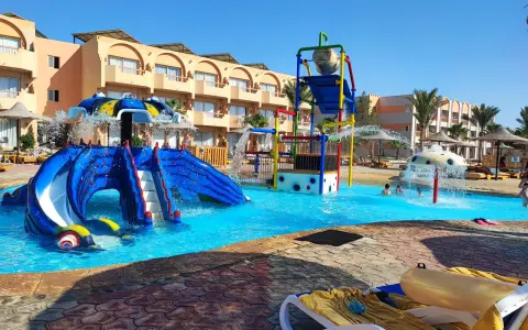Divertimento acquatico a Marsa Alam con bambini: scivoli blu, giochi d'acqua e piscine cristalline in un resort soleggiato.
