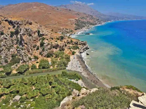 Spiaggia con palme e fiume in Grecia, ideale per una vacanza in famiglia in un grecia family hotel.
