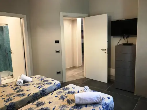 Camere con letti gemelli, biancheria a tema marino, bagno con doccia e TV. Un vero eden capo vaticano.